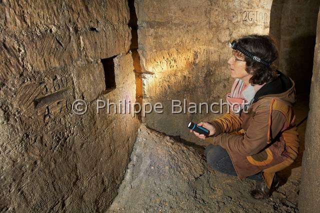 PBL_Araignees_2014_MG_8282.JPG - France, Paris (75), Muséum national d'Histoire naturelle, Christine Rollard, aranéologue, éclairant une cavité dans les carrières souterraines sous le jardin des plantes, in "Portraits d'araignées" de Christine Rollard et Philippe Blanchot, ed. Quae